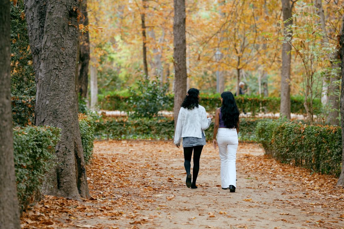 Twee mensen lopen samen over een bospad in de herfst