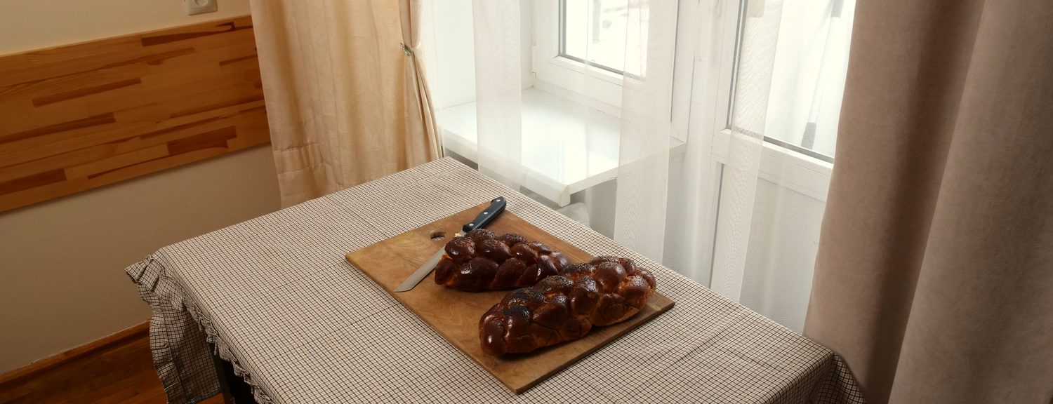 Houten eettafel bij het raam met een plank vers brood