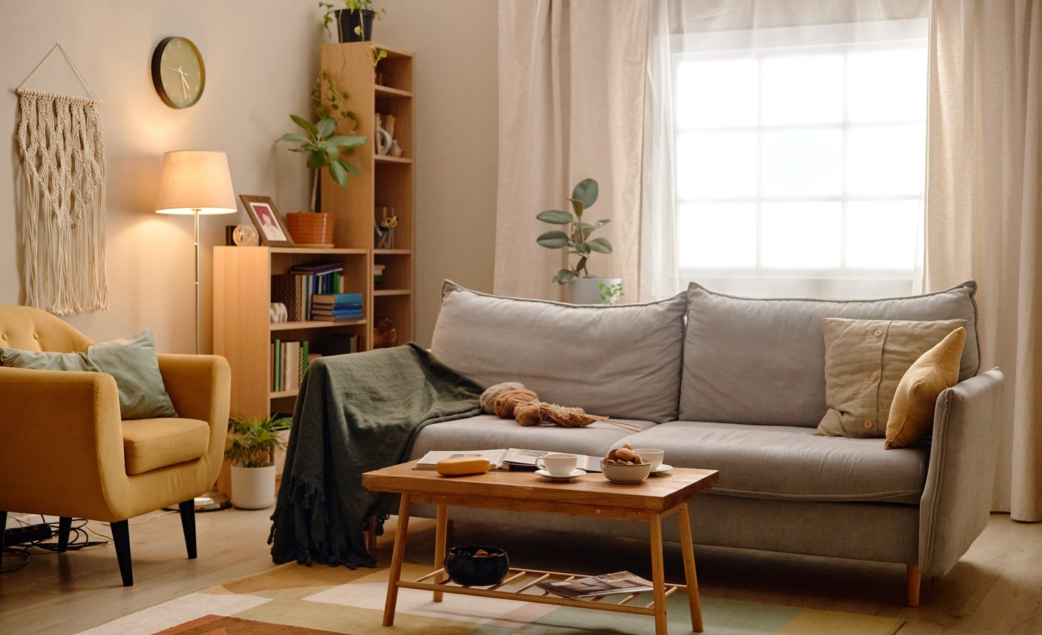 Woonkamer met bank, fauteuil en een brandende schemerlamp